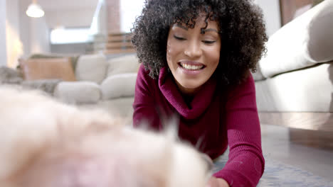 Feliz-Mujer-Birracial-Acariciando-Perro-Golden-Retriever-En-Casa,-Cámara-Lenta