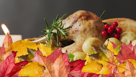 Animation-of-autumn-leaves-over-thanksgiving-dinner-background