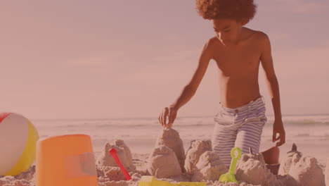 Un-Joven-Afroamericano-Construyendo-Castillos-De-Arena-En-La-Playa.