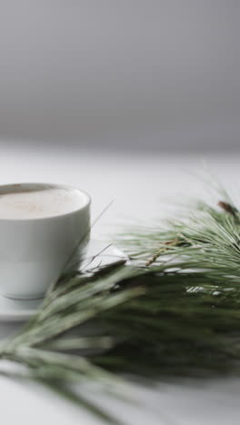 Vídeo-Vertical-De-Una-Taza-De-Chocolate-Navideño-Con-Rama-De-Abeto-Y-Espacio-Para-Copiar-Sobre-Fondo-Blanco