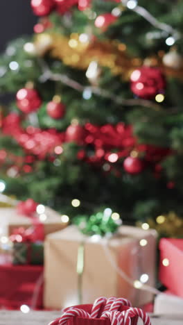 Vertikales-Video-Von-Weihnachtszuckerstangen-In-Tasse,-Weihnachtsbaum-Und-Kopierraum