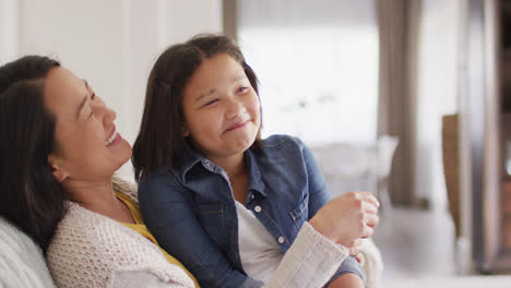 Video-Einer-Glücklichen-Asiatischen-Mutter-Und-Tochter,-Die-Auf-Dem-Sofa-Sitzen-Und-Spaß-Haben