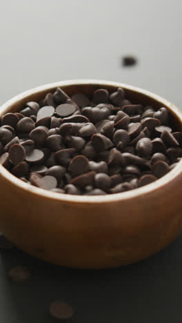 Video-of-wooden-bowl-of-chocolate-chip-over-grey-background