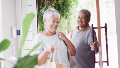 Feliz-Pareja-Senior-Diversa-Regresando-A-Casa-Con-Compras