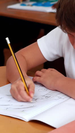 Vídeo-Vertical-De-Un-Niño-Caucásico-Centrado-En-Escribir-En-Un-Cuaderno-En-La-Escuela