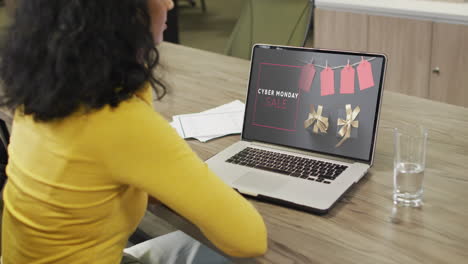 Mujer-Birracial-En-La-Mesa-Usando-Laptop,-Compras-En-Línea-Durante-La-Venta-Del-Lunes-Cibernético,-Cámara-Lenta