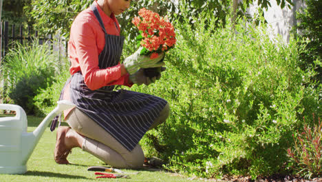 Video-Einer-Frau-Mit-Gemischter-Abstammung-Im-Hijab,-Die-Im-Garten-Blumen-Pflanzt