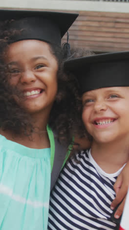 Video-of-happy-diverse-girls-wearing-graduation-hats-and-holding-diplomas