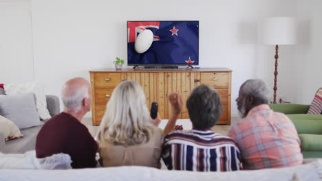 Diversos-Amigos-Mayores-Viendo-Televisión-Con-Una-Pelota-De-Rugby-En-La-Bandera-De-Nueva-Zelanda-En-La-Pantalla