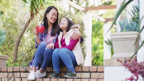 Video-De-Feliz-Madre-E-Hija-Asiáticas-Abrazándose-Y-Divirtiéndose-En-El-Jardín