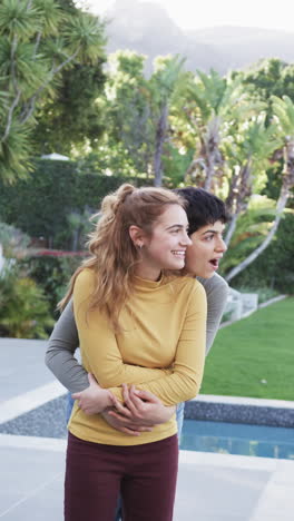 Feliz-Pareja-De-Lesbianas-Caucásicas-Abrazándose-Y-Sonriendo-En-El-Soleado-Jardín