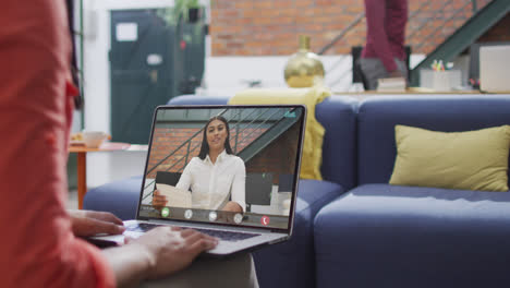 Biracial-businesswoman-using-laptop-for-video-call-with-biracial-business-colleague