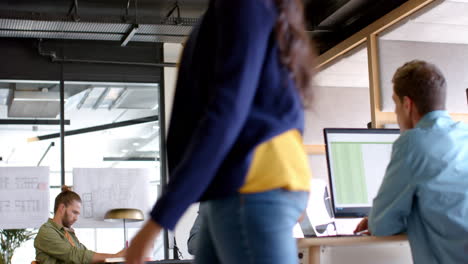 Young-Caucasian-man-works-on-a-computer-in-a-modern,-casual-business-office