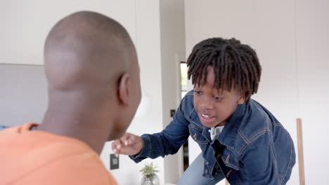 Happy-african-american-father-and-son-embracing-at-home,-slow-motion