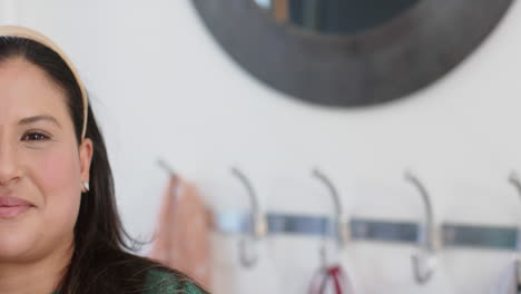 Half-face-of-happy-biracial-woman-standing-and-smiling-in-sunny-house