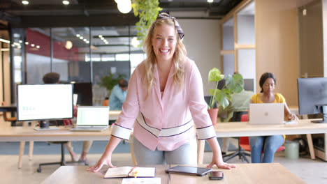 Portrait-of-happy-caucasian-casual-businesswoman-standing-in-office-smiling,-slow-motion