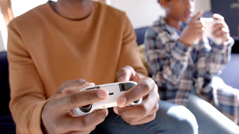 African-american-father-and-son-playing-video-games-at-home,-slow-motion