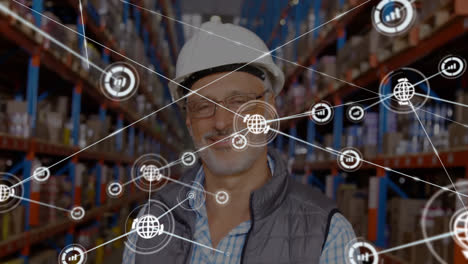 Animation-of-network-of-connections-with-icons-over-caucasian-man-working-in-warehouse