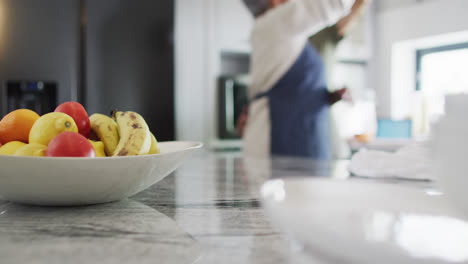 Happy-senior-biracial-couple-dancing-in-kitchen