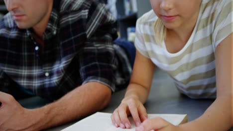 Animation-Von-Schulkonzeptsymbolen-über-Einem-Kaukasischen-Männlichen-Lehrer-Und-Einem-Mädchen,-Das-In-Der-Bibliothek-In-Der-Schule-Lernt