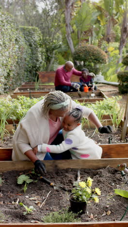 Feliz-Abuela-Y-Nieta-Afroamericana-Abrazándose-En-Un-Jardín-Soleado,-Cámara-Lenta