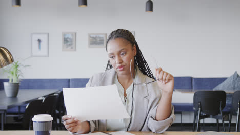 Seria-Mujer-De-Negocios-Afroamericana-Casual-Mirando-Documentos-Durante-Videollamada,-Cámara-Lenta