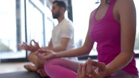 Biracial-couple-doing-yoga-and-meditating-at-home,-in-slow-motion