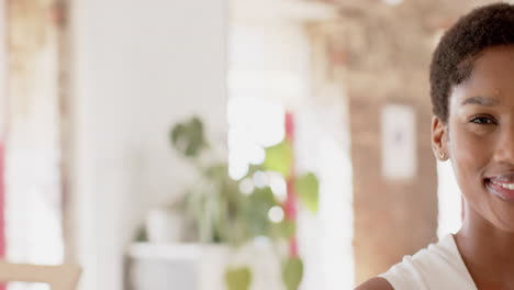 Young-African-American-businesswoman-smiles-warmly-in-a-bright-office-with-copy-space