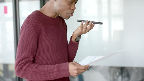 African-american-casual-businessman-talking-on-smartphone-at-home-office,-slow-motion