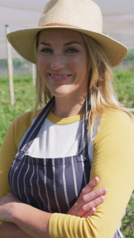 Video-of-happy-caucasian-woman-wearing-apron-and-standing-in-greenhouse