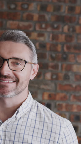 Vertical-video-half-portrait-of-senior-caucasian-casual-businessman-smiling-at-office