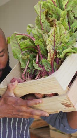 Video-De-Un-Feliz-Vendedor-Afroamericano-De-Pie-Con-Una-Caja-De-Verduras-En-Una-Tienda-De-Comestibles-Orgánicos