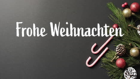 Frohe-Weihnachten-Text-With-Candy-Canes,-Christmas-Tree-Branch-And-Baubles-On-Grey-Background