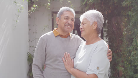 Retrato-De-Una-Feliz-Pareja-Diversa-Senior-Mirando-La-Cámara-En-El-Jardín