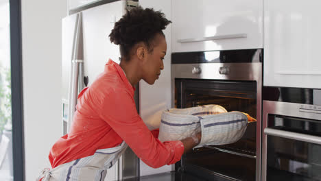 Video-of-african-american-woman-taking-out-cake-from-oven