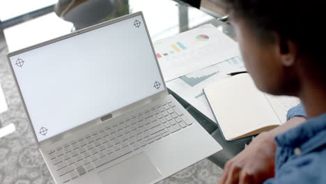 African-american-casual-businessman-at-desk-using-laptop-with-copy-space-on-screen,-slow-motion