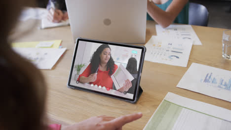 Caucasian-businesswoman-on-tablet-video-call-with-african-american-female-colleague-on-screen