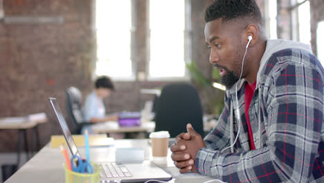 Focused-african-american-casual-businessman-having-laptop-video-call-in-office-in-slow-motion