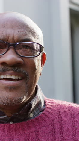 Halbes-Gesicht-Eines-Glücklichen-Afroamerikanischen-Seniors,-Der-Vor-Dem-Haus-Steht-Und-Lächelt,-Zeitlupe