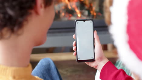 Diverse-gay-male-couple-using-smartphone-with-copy-space-for-video-call-at-home,-slow-motion