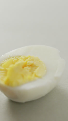 Video-of-close-up-of-three-halves-of-hard-boiled-eggs-on-grey-background