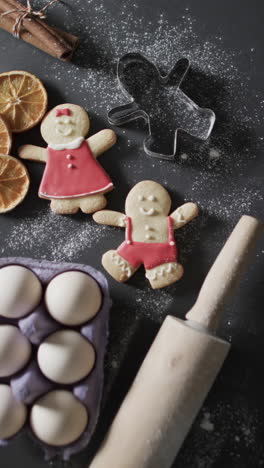 Vertical-video-of-christmas-cookies-with-sugar-and-copy-space-on-black-background