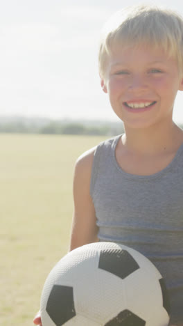 Video-De-Un-Niño-Caucásico-Feliz-Sosteniendo-Una-Pelota-En-El-Campo-De-Deportes