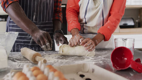 Video-of-midsection-of-african-american-couple-baking-together,-preparing-dough