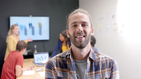 Portrait-of-happy-caucasian-casual-businessman-with-colleagues-in-meeting-room,-slow-motion