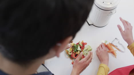 Feliz-Pareja-De-Lesbianas-Caucásicas-Preparando-Comida-En-La-Soleada-Cocina