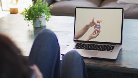 Woman-at-table-using-laptop,-online-shopping-for-beauty-products,-slow-motion