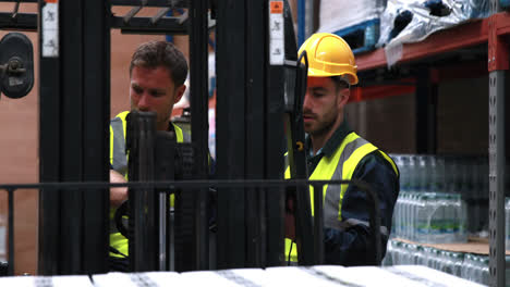 Trabajador-De-Almacén-Hablando-Con-El-Conductor-Del-Montacargas-