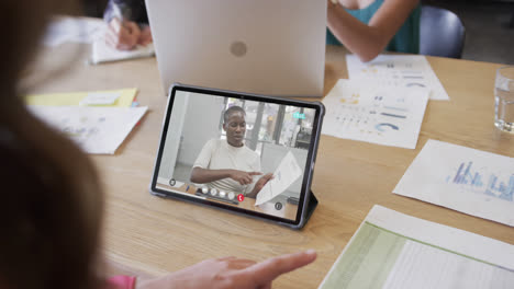 Caucasian-businesswoman-on-tablet-video-call-with-african-american-female-colleague-on-screen