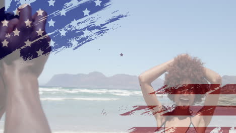 Animation-Des-Designs-Der-US-Flagge-Vor-Einem-Afroamerikanischen-Mann,-Der-Am-Strand-Fotos-Von-Seiner-Frau-Macht